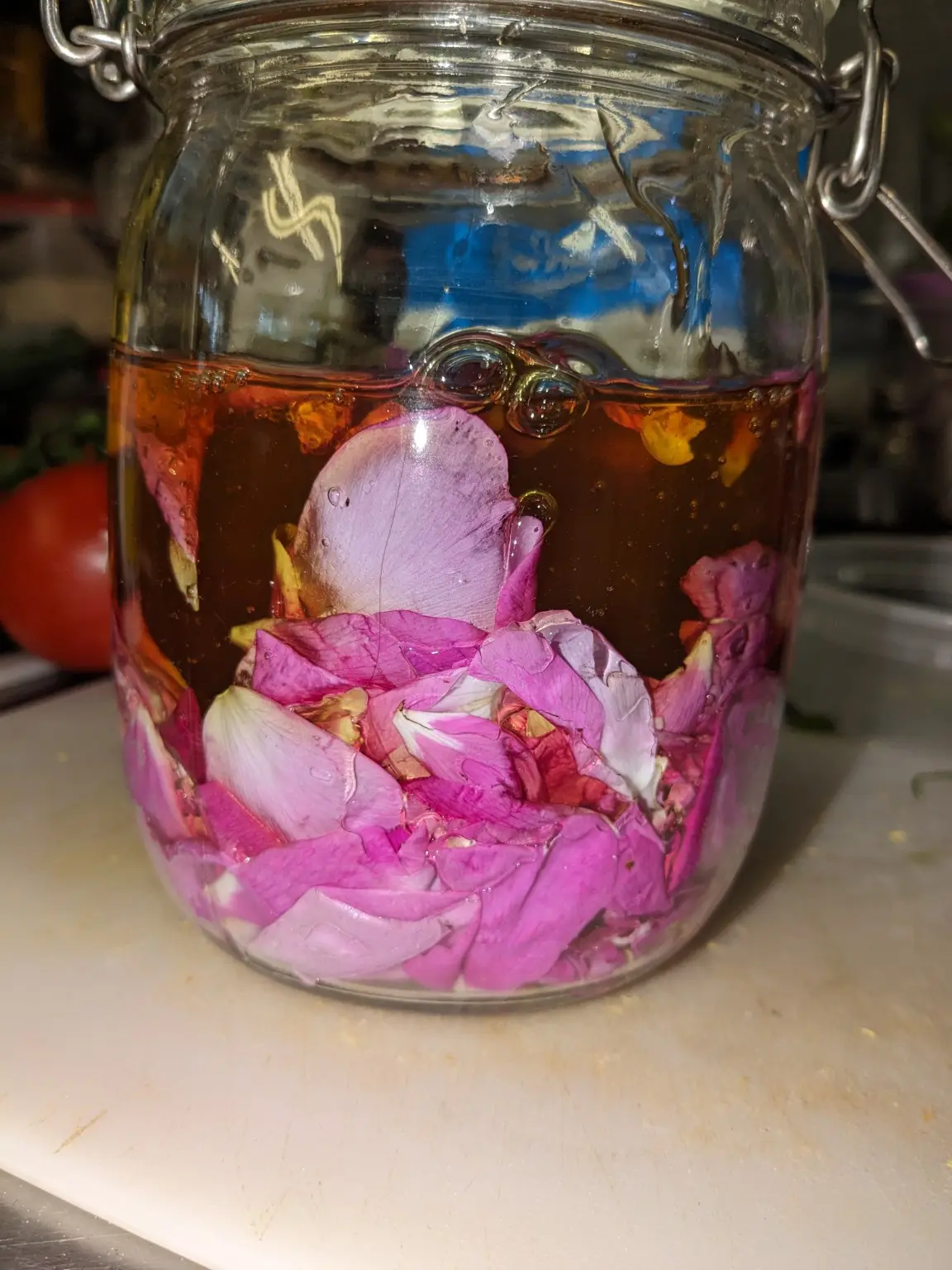 Rose petals infusing in a glass jar